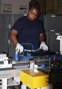 A Halla worker checks equipment in company's Macon County plant.