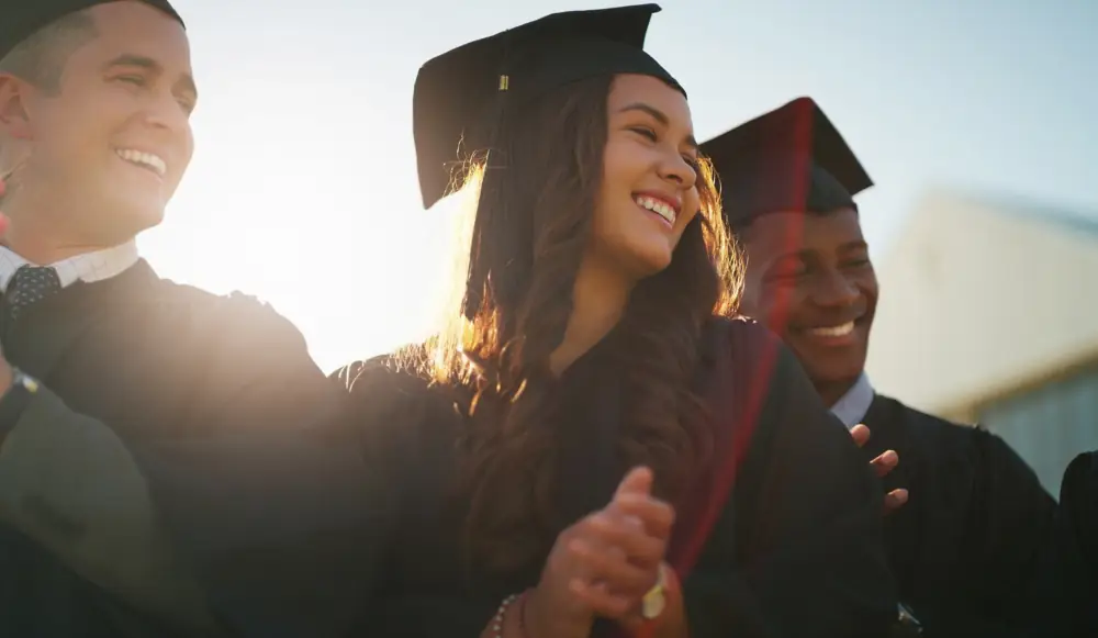 High-school aged men and women wearing graduation cloaks and hats.