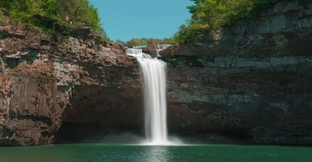A waterfall at DeSoto Falls, Alabama taken from across the pool, showing the rock formations around the waterfall.